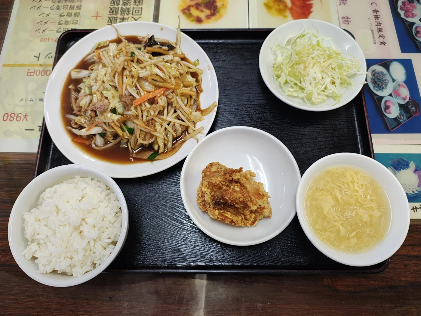 炒め物、ご飯、唐揚げ、スープが並ぶ定食